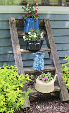 an old wooden ladder is used as a planter for flowers and other plants in the garden