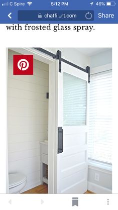 an open sliding door in a bathroom with wood flooring and white paint on the walls