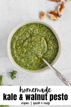 homemade kale and walnut pesto in a white bowl with a spoon on the side