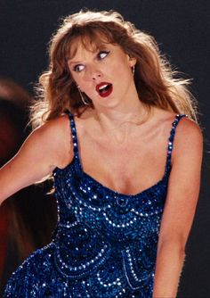 a woman in a blue dress holding a tennis racquet