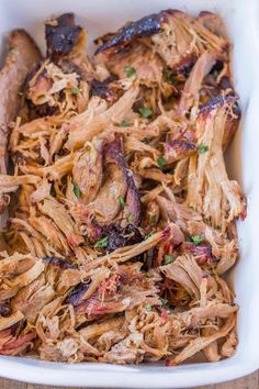 pulled pork in a white casserole dish with text overlay that reads easy - no - grill bbq pulled pork