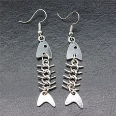 Fish Bone Drop Earrings Add a touch of whimsy to your outfit with our Fish Bone Drop Earrings. These unique earrings feature a fun and playful fish bone design, perfect for any fashion-forward individual. Made with high-quality materials, they are lightweight and comfortable to wear. Accessorize with these earrings for a fun and stylish look. Fish Skeleton Earrings, Fish Bone Jewelry, Fishbone Jewelry, Octopus Earrings, Weird Earrings, Fish Earrings, Bone Earrings, Ocean Fashion, Funky Earrings