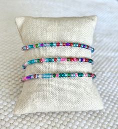 three bracelets sitting on top of a pillow