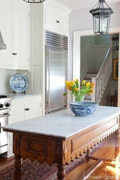 a kitchen with an island in the middle and yellow flowers on it's counter