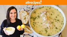 a woman holding two lemons and a bowl of soup with bread on the side