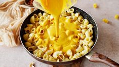 macaroni and cheese being poured into a pan