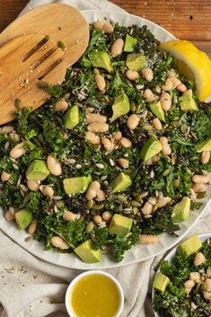 a white plate topped with kale salad next to two small bowls filled with avocado