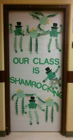 a classroom door decorated with green and white paper cutouts that says our class is shamrocking