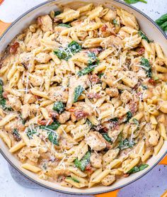 a skillet filled with chicken and spinach pasta