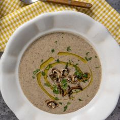 a white bowl filled with soup and topped with mushrooms