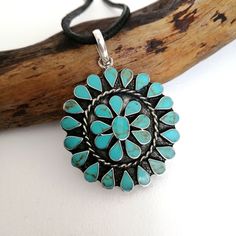 "This stunning Squash Blossom pendant was handcrafted in Mexico. Each teardrop bezel is inlaid with turquoise coloured enamel enhanced with tiny brown flecks. Surrounding the centre blossom is a woven wire accent. Complete with an 18\" inch black cord ready to wear! The pendant is approximately 2\" inches long. This piece is silver plated. The pattern of the enamel may vary very slightly, they are all individually hand crafted. If you've got any questions don't hesitate to ask me. This pendant c Turquoise Concho Bohemian Necklace, Adjustable Southwestern Turquoise Pendant Necklace, Turquoise Bohemian Concho Necklace, Southwestern Turquoise Necklace For Festivals, Southwestern Style Turquoise Necklace For Festivals, Blue Bohemian Concho Necklace, Bohemian Blue Concho Necklace, Handmade Southwestern Teardrop Pendant Necklace, Handmade Southwestern Necklace With Teardrop Pendant