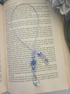 an open book with a necklace on top of it