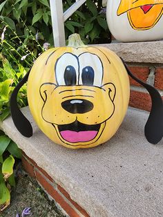 a pumpkin with goofy face painted on it