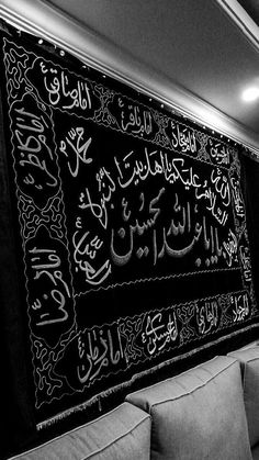 a black and white photo of arabic calligraphy on a wall in a living room