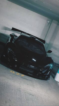 a black sports car parked in a parking garage