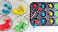 four plastic trays filled with different colored play dough next to a muffin tin