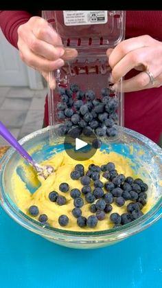 a person is mixing blueberries in a bowl