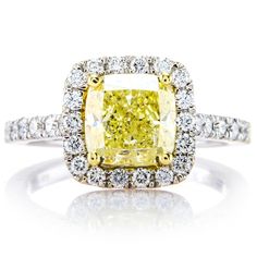 a fancy yellow diamond ring with diamonds around it