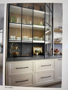 a kitchen with white cabinets and shelves filled with glassware on top of it's counter tops