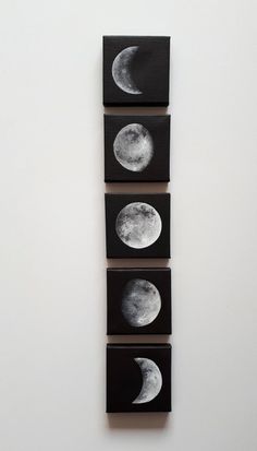 three small black and white paintings with the moon in it's center, hanging on a wall