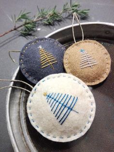 three ornaments are sitting in a metal bowl