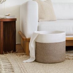 a white couch sitting next to a wooden table on top of a carpet covered floor