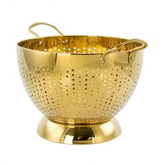 a gold colored colander with handles and holes on the bottom, sitting on a white background