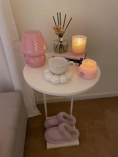 a white table topped with candles and slippers