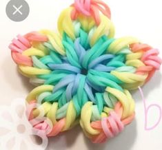 an image of a flower made out of rainbow loom beads on a white background