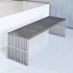 a metal bench sitting on top of a white tile floor next to a wall and window