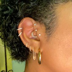 a close up of a person with ear piercings on their ears and behind the ear