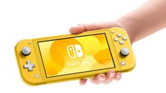 the nintendo switch is being held up by someone's hand and it appears to be yellow