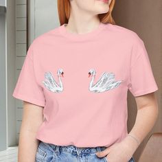 In our soft girl era. 🦢🎀 Perfect gift for the girlie girl in your life! Put on your favorite Lana album and indulge in feeling your feels while you wear this comfy, 90s aesthetic tee. Coquette swan shirt, coquette shirt, swan gift, bird lover, bow shirt, soft girl era, girlie girl shirt, ribbon shirt, trendy crewneck This classic unisex jersey short sleeve tee fits like a well-loved favorite. Soft cotton and quality print make users fall in love with it over and over again. These t-shirts have-ribbed knit collars to bolster shaping. The shoulders are tapered for a better fit over time. Dual side seams hold the garment's shape for longer. ★SHIPPING★ -Ships from Florida -Processing time: 1-2 days -Delivery time: 4-8 business days ★CARE INSTRUCTIONS★ -Machine wash: cold (max 30C or 90F) -No Feminine Pink Crew Neck T-shirt, Feminine Crew Neck T-shirt For Spring, Feminine Crew Neck T-shirt, Feminine Pink Summer T-shirt, Pink Flamingo Print Short Sleeve T-shirt, Pink Short Sleeve T-shirt With Flamingo Print, Casual Spring Tops With Flamingo Print, Casual Pink Flamingo Print T-shirt, Casual Flamingo Print Tops For Spring