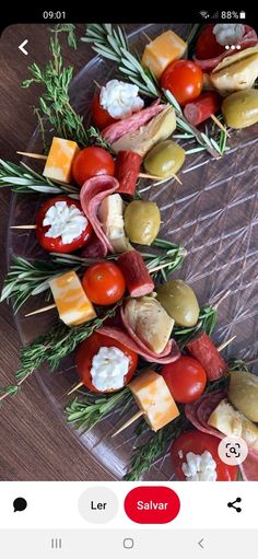 an appetizer platter with meat, cheese and vegetables on skewers