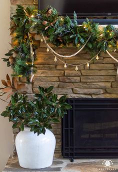 a fireplace decorated with greenery and lights