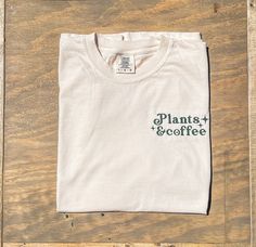 Machine embroidered sketch stitch Plants & Coffee text with star design. Vintage style font. comfort colors brand tee shirt - unisex sizing. Natural color t shirt with dark green design Green Casual T-shirt With Embroidered Text, Green Short Sleeve T-shirt With Embroidered Text, Green Embroidered Text Short Sleeve T-shirt, Vintage Embroidered Cotton T-shirt, Green Cotton T-shirt With Embroidered Graphics, Green Relaxed Fit T-shirt With Embroidered Graphics, Coffee Cotton T-shirt With Text Print, Everyday Coffee-colored T-shirt With Text Print, Embroidered Tee