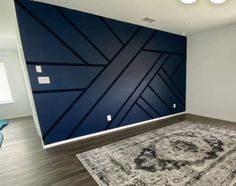 an empty room with a rug and blue walls