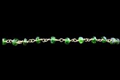 a green beaded bracelet on a black background