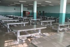 an empty cafeteria with tables and benches in the middle of the room is seen here