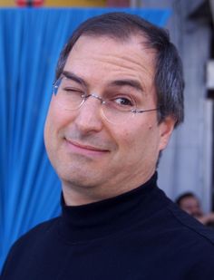 a man with glasses is smiling for the camera