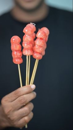 a man is holding up some candy lollipops