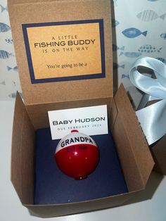 a baby hudson ornament in a box with a white ribbon on the side