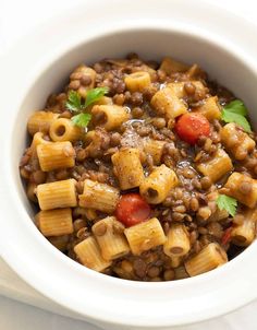 a white bowl filled with pasta and meat