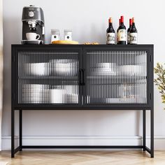 a black metal cabinet with wine bottles and cups on top, next to a coffee maker