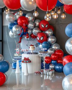 a spiderman themed birthday party with balloons and cake