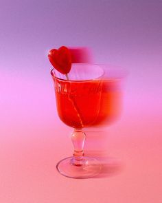 a glass filled with liquid and a heart shaped object