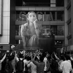 a group of people standing around a large poster