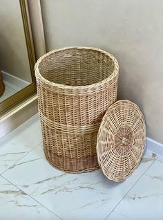 two wicker baskets sitting on the floor next to a mirror