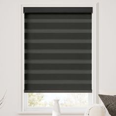 a black roller blind in front of a window with the blinds pulled back to reveal dark grey stripes