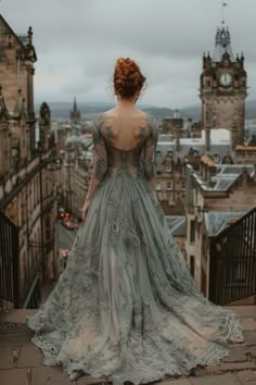 a woman standing on top of a building looking down at the city below her back